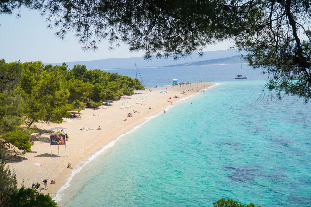 zlatni rat beach in Croatia, people sunbathing and sailboats